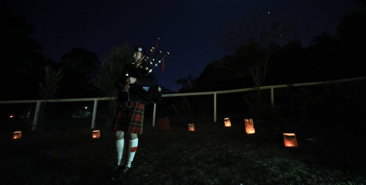 SERVICE: Piper Neil Johnstone from the Illawarra Pipe Band plays during the ceremony on Friday night. Picture: Adam McLean