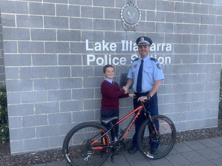RETURNED: Lake Illawarra Chief Inspector Paul Allman returns the stolen bike to Oak Flats boy Levi Tickner on Wednesday. The bike was stolen from outside a takeaway business on Central Avenue on Monday. Picture: Supplied