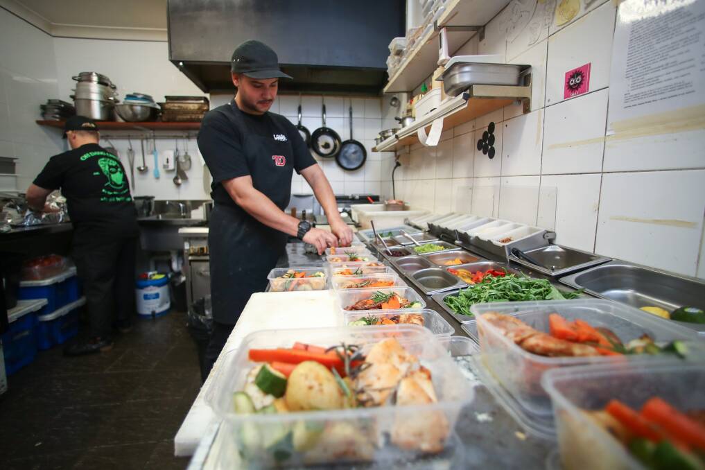 PROGRAM: Lower East Cafe's Jonathan Harrington preparing the meals on Monday. SmartMeals partners with cafes and restaurants to provide subsidised meals for homeless community groups. Picture: Adam McLean