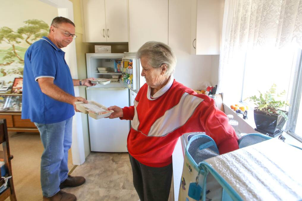 KEY SERVICE: Meals On Wheels volunteer Bruce Kafer with 91-year-old Port Kembla resident and client Val Beazley on Wednesday. Mr Kafer says the organisation is in desperate need of more funds. Picture: Adam McLean