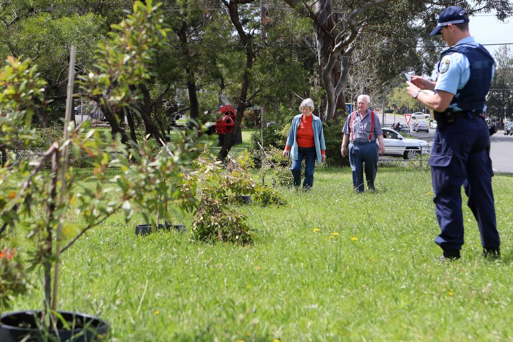 INCIDENT: Dave and Kay Cox surveying the vandalism of trees in the reserve, with Wollongong police's Constable Catlin. Picture: Sylvia Liber