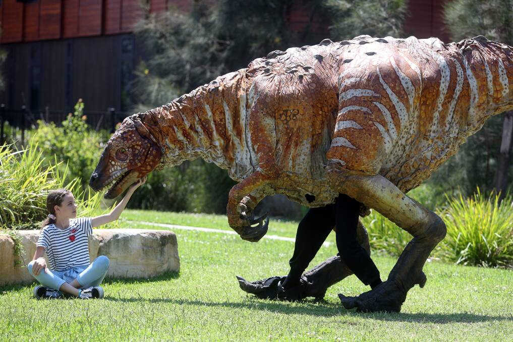 LEARNING: Dapto's Caitlin Young with one of the visiting 'dinosaurs' at the Innovation Campus' Science Space on Tuesday. Picture: Robert Peet