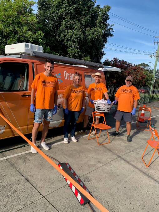HELPING HANDS: Orange Sky volunteers Alex Bausch, Elise Wesley, Michael Todd and Tony Young in action in the Illawarra on Friday. Picture: Supplied 