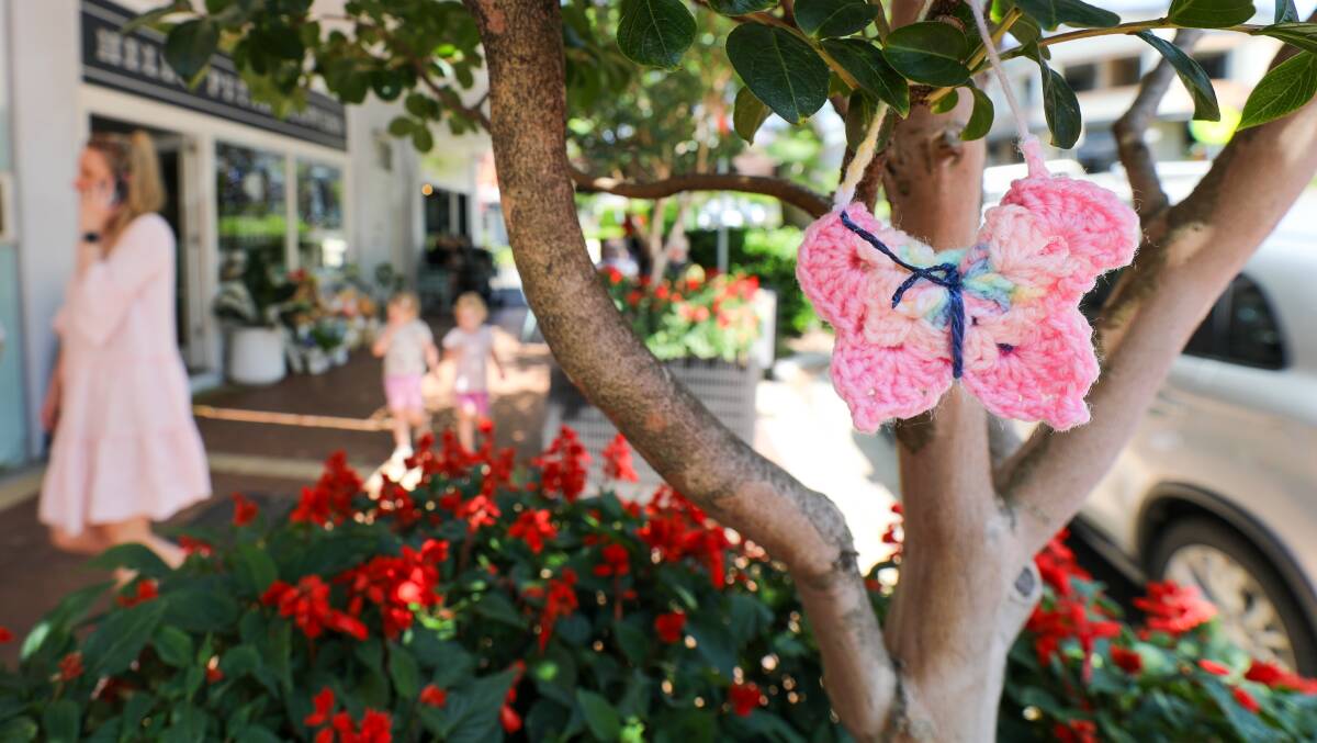 A pink crochet butterfly hangs from a tree in Keiraville.