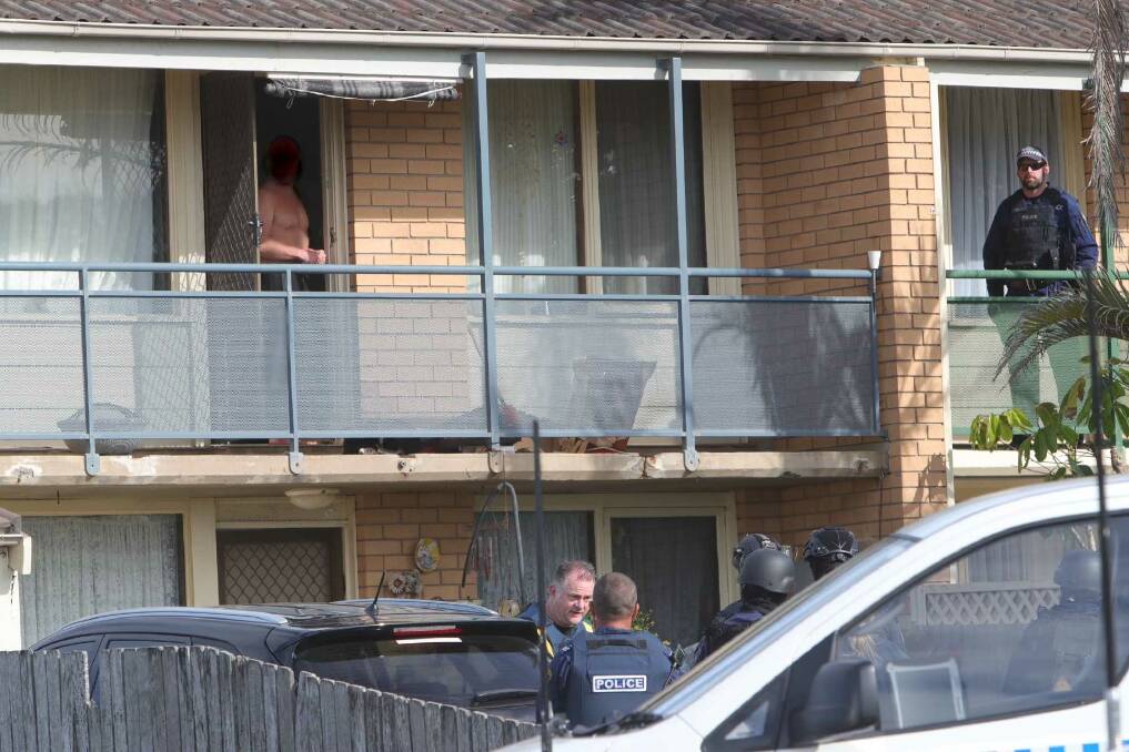 A man emerges from a Bellambi townhouse at the centre of a police operation. Photo: Sylvia Liber