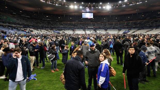 Spectators gather on the pitch after the bombings at the Stade de France. Photo: Getty Images