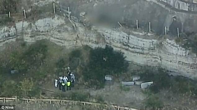 Rescue crews near the base of the cliff where a 24-year-old man fell to his death. Photo: Nine Network