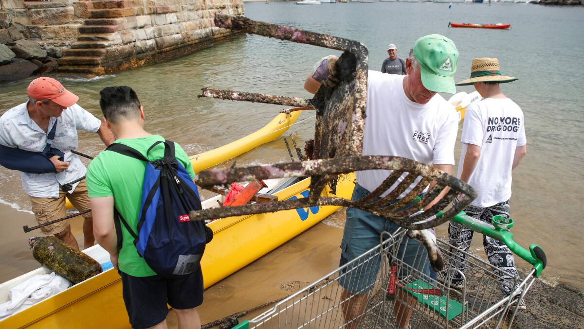 Volunteers remove a trolley and chair from Wollongong Harbour. Photo: Adam McLean.