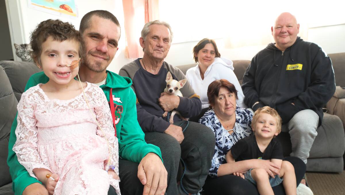 From left: Ella Rose Valesini (7) with father Mitchell Valesini and her family at home in Koonawarra. Photo: Adam McLean