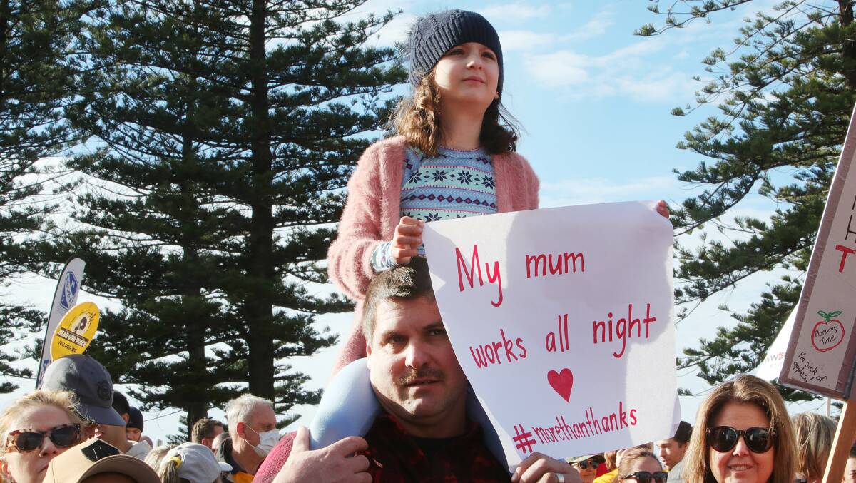 The child of a teacher holds up a sign at a rally in July. Pictures by Sylvia Liber