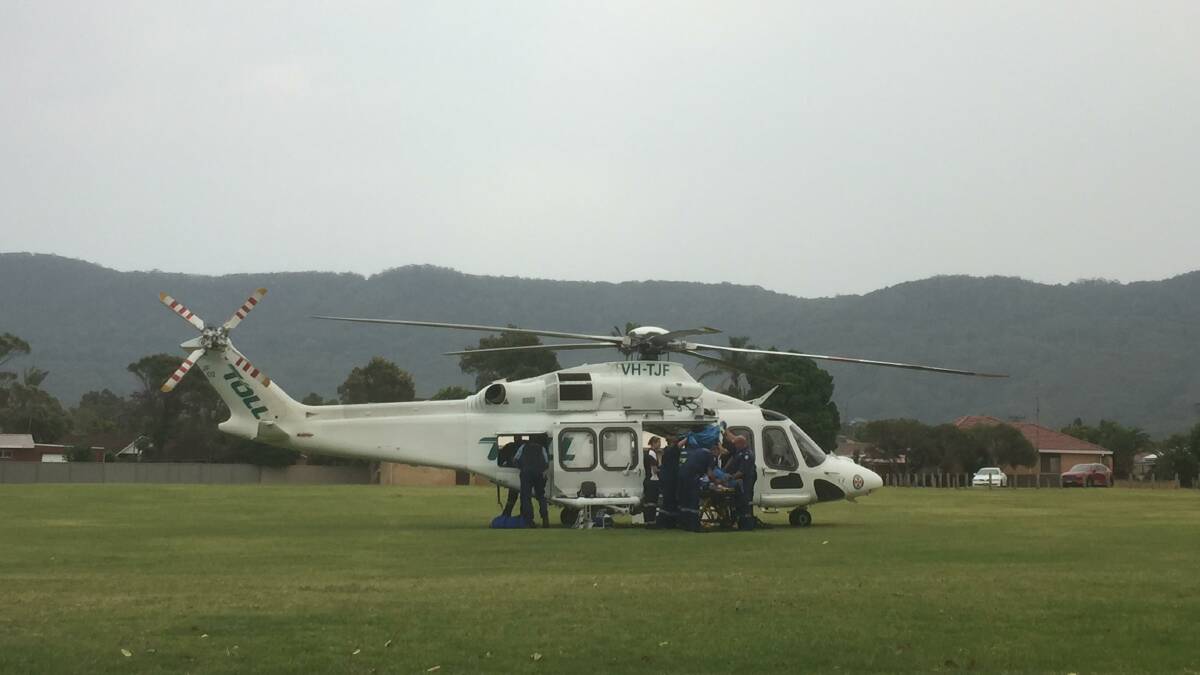 Paramedics treat the patient before loading him onto the rescue chopper at Guest Park. Photo: Anna Warr