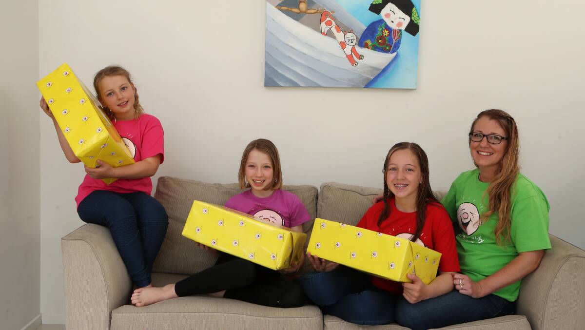 Camp-in-a-box mystery: Jane Sandelin (right) with her daughters Lara, 8, Katie, 11, and Krystle,13, who are champing at the bit to see what's inside their Camp Quality Virtual Camp mystery boxes. Picture: Sylvia Liber.