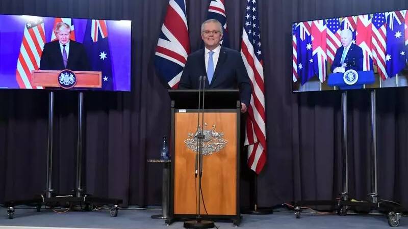 Scott Morrison, with Boris Johnson and Joe Biden on screens by his side, announcing an alliance between Australia, UK and US dubbed AUKUS in March 2023.