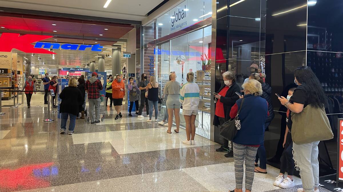 Shoppers queue to get into Kmart at Stockland Shellharbour on Monday morning. Photo: Sylvia Liber