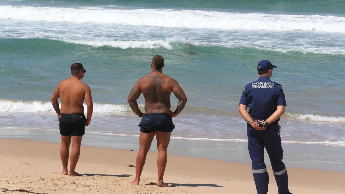 Two men, believed to be Mr Bubanja's brothers, waiting anxiously at the beach on Wednesday.