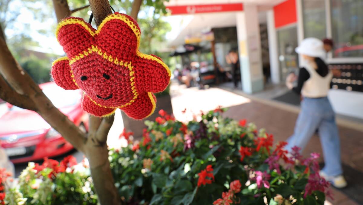 A crochet flower hangs from a tree outside the shops on Gipps Road in Keiraville. Picture by Adam McLean