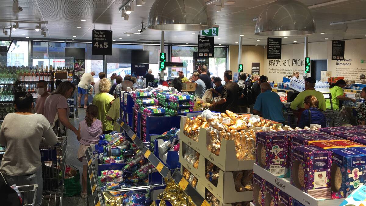 Shoppers strip the shelves bare of everything but the chocolate Easter eggs at Dapto Aldi on Wednesday. Photos: Robert Peet