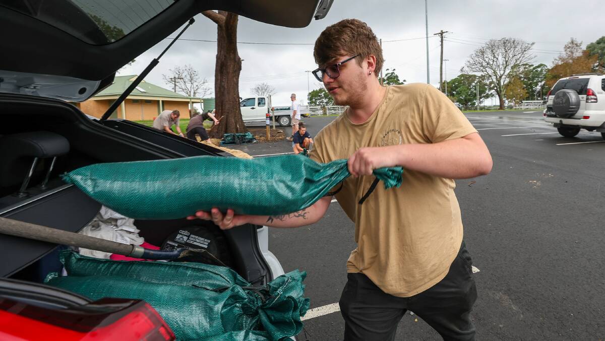 Mark Nicholls with sandbags to help protect homes from 300mm of rain predicted in the Illawarra. Picture by Adam McLean