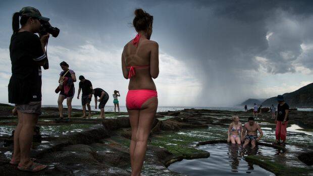 Tourists pose for photographs at the Figure Eight Pools in the Royal National Park. Photo: Wolter Peeters
