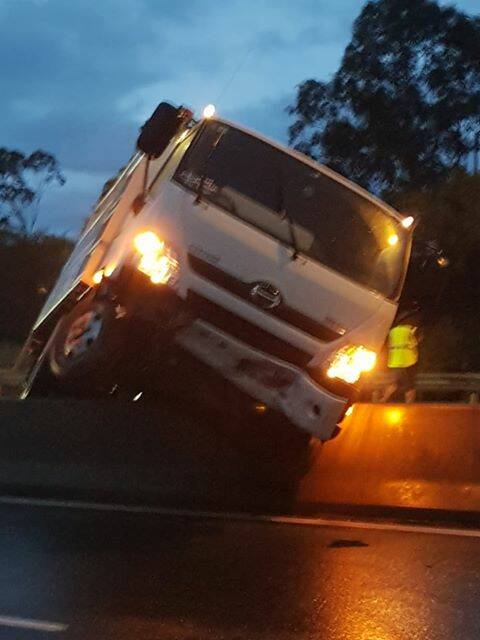 A truck comes to rest on the median barrier on the Princes Highway. Photos: Jarrad Borg