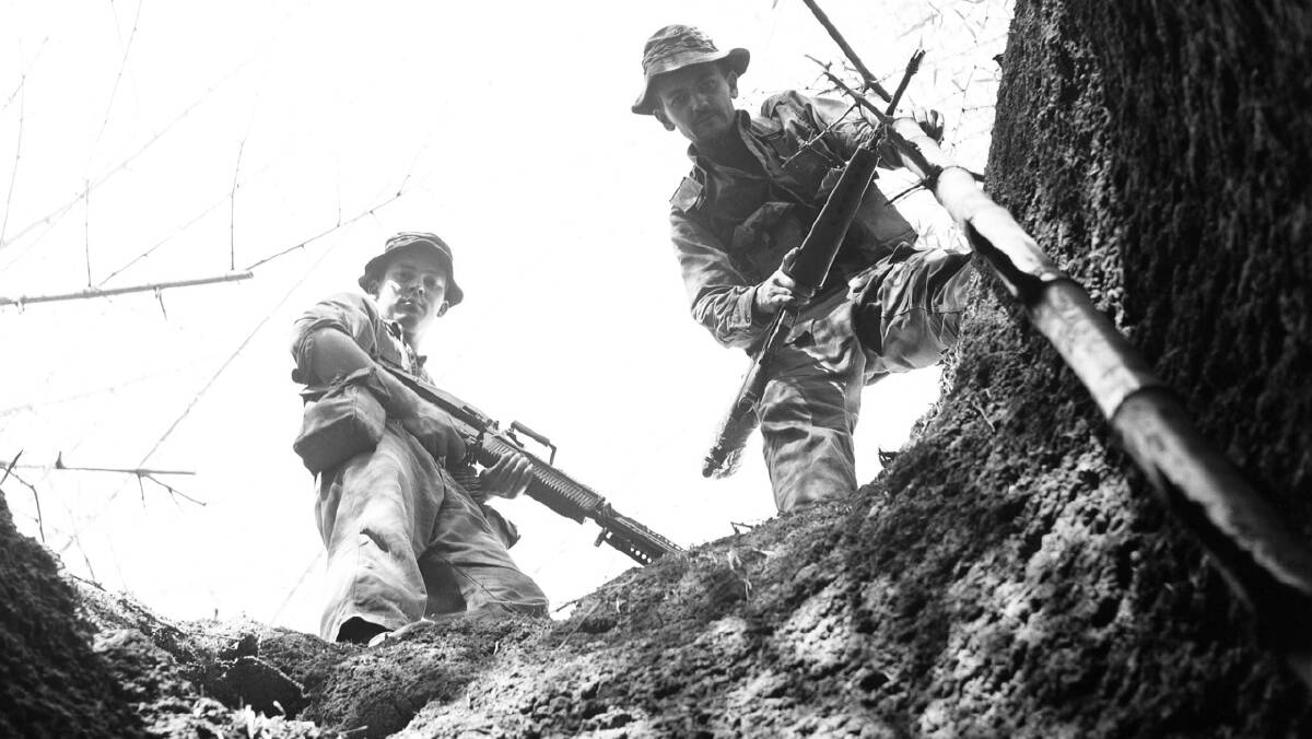 Two Australian troopers look into a Viet Cong well at a bunker system near Long Tan, near the Australian task force base at Nui Dat. Picture: John Fairley, courtesy Australian War Memorial FAI/70/0337/VN.
