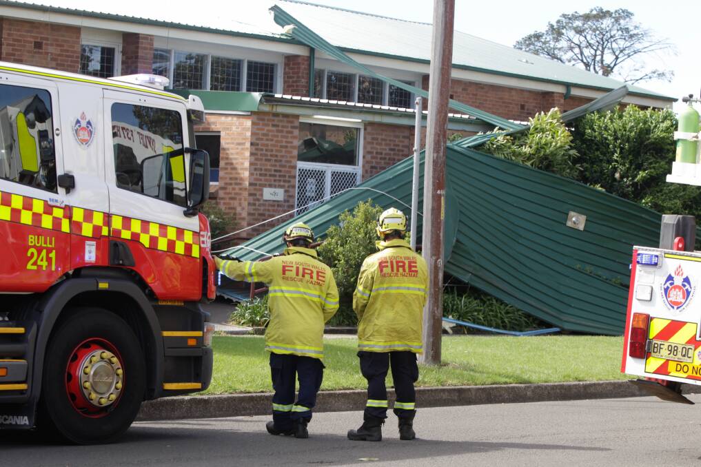 Fire and Rescue NSW members on the scene after wild winds ripped a section of the Bulli PCYC's roof off on Sunday. Gusts of 95km/h and 82km/h were recorded at Bellambi and Albion Park, respectively. Picture: Georgia Matts