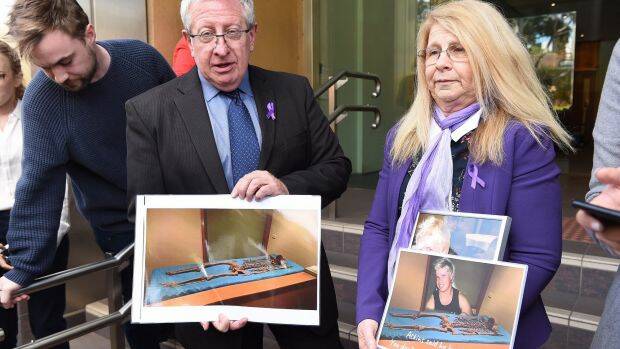 Mark and Faye Leveson hold photos of the skeletal remains of their son Matthew Leveson after giving their impact statement at the Coroner's Court on Friday. Photo: Kate Geraghty
