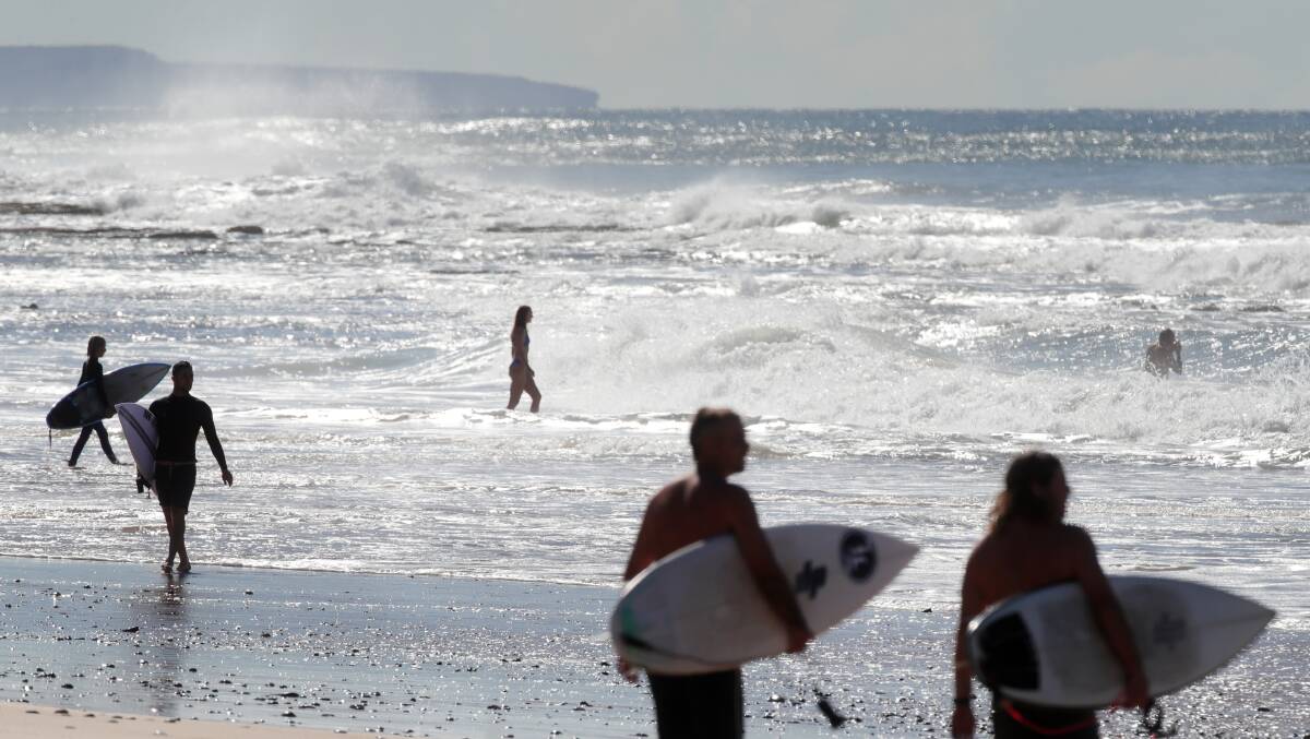 Surfers and swimmers enjoy the water at Thirroul Beach during the April school holidays. Photo: Sylvia Liber