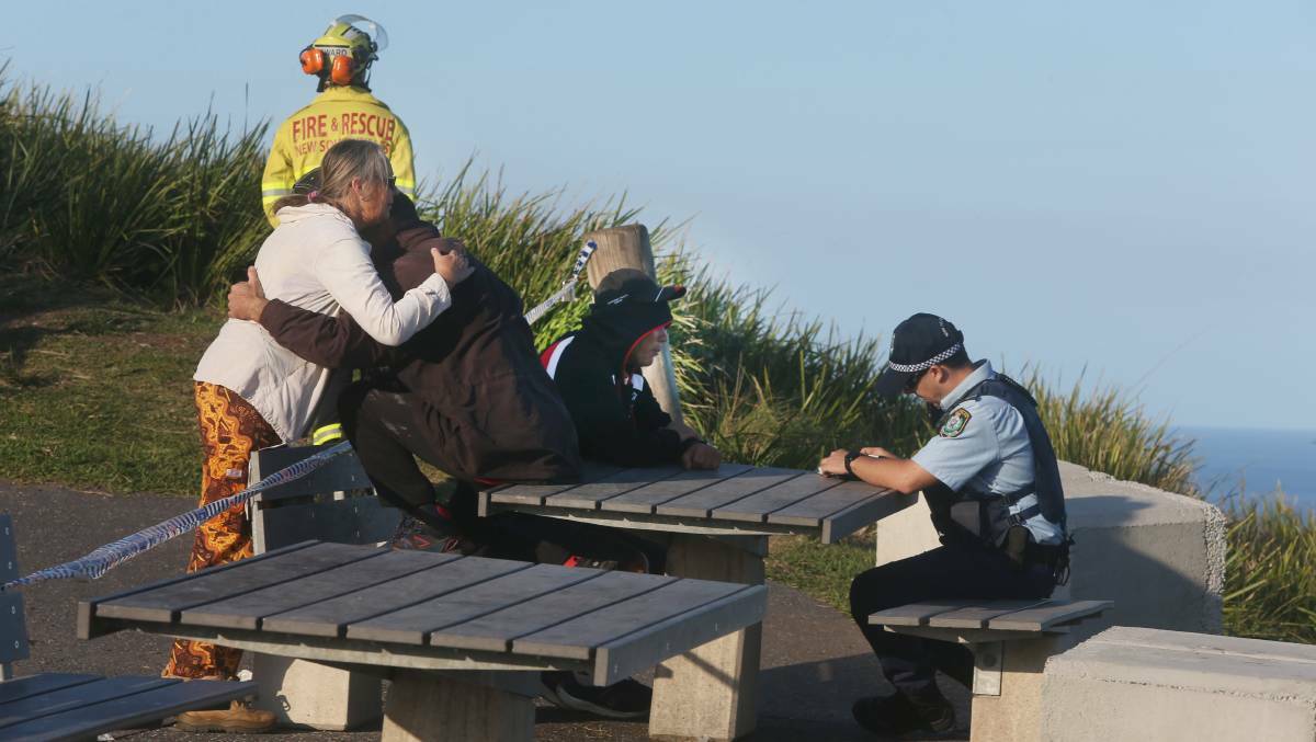 Distressed witnesses comfort each other at Bald Hill on Sunday. Photo: Robert Peet