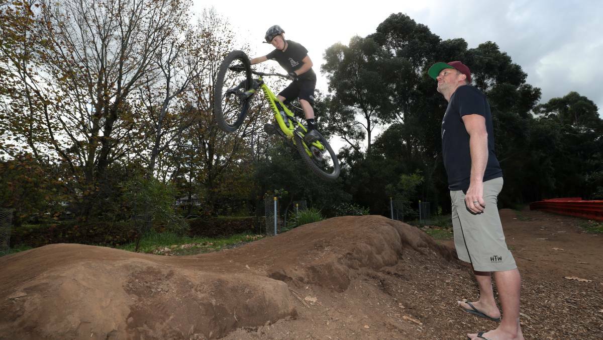  Cohen Armstrong, 11, takes on the pump track at Harry Graham Park, while dad Paul watches on. Photo: Robert Peet