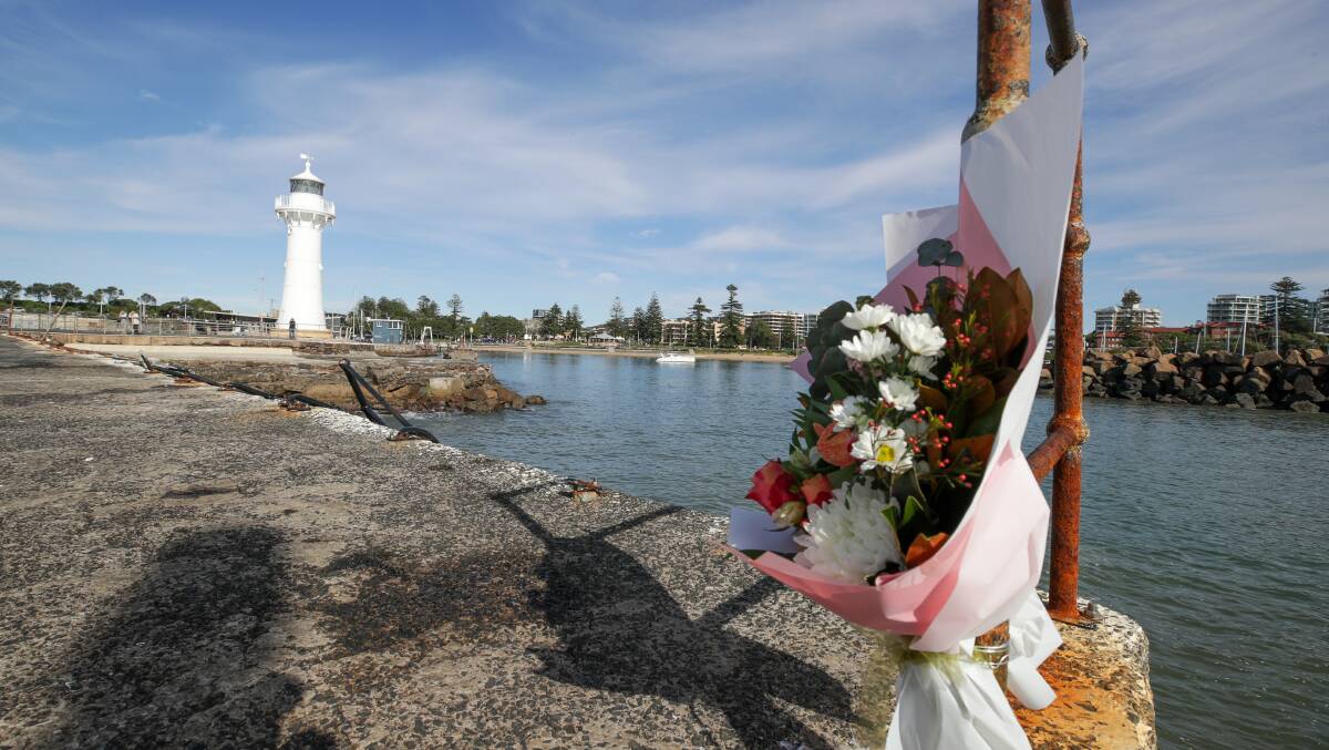 Flowers left at Wollongong Harbour breakwall where a man drowned yesterday. Photos: Adam McLean