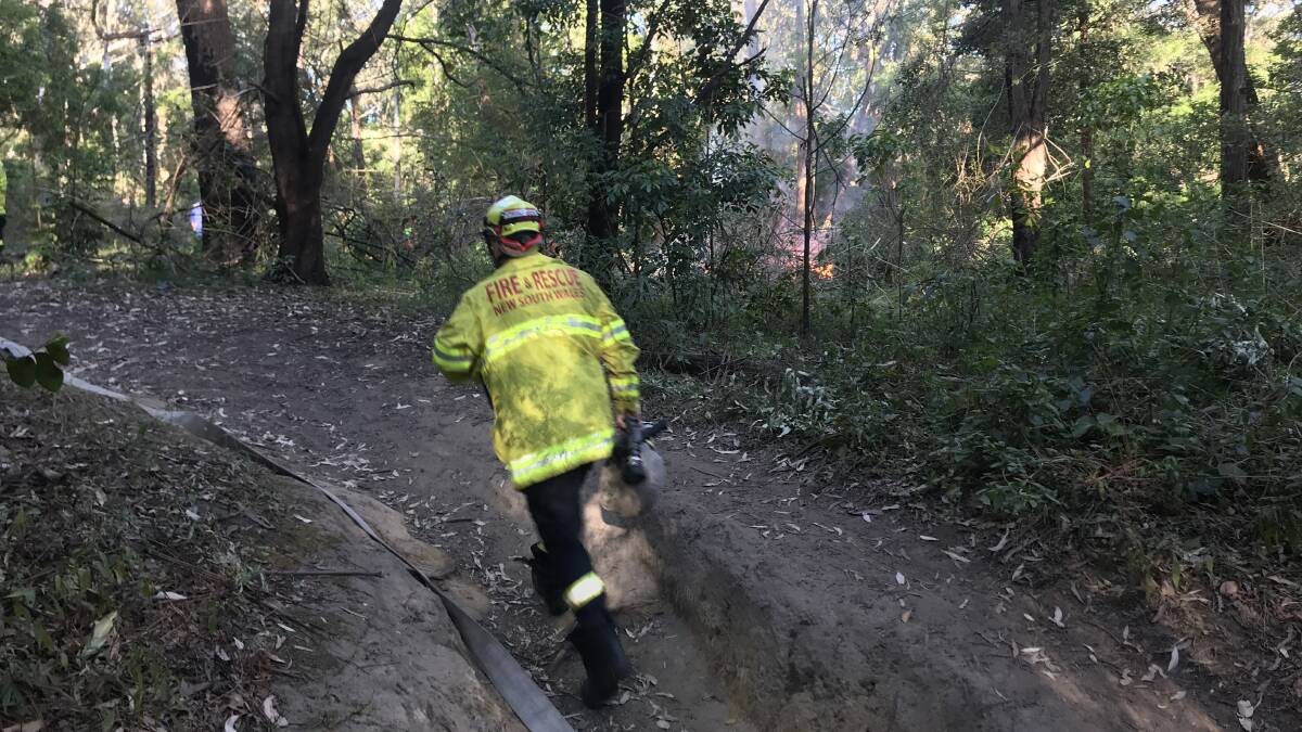Fire fighters work to extinguish the small blaze in Balgownie. Photo: Ashleigh Tullis 