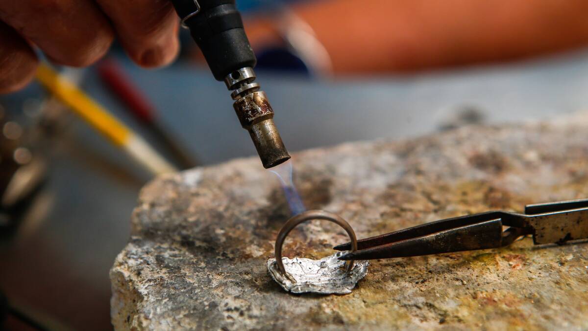 An Illawarra Lapidary Club member uses a torch to make jewellery in Tarrawanna. 