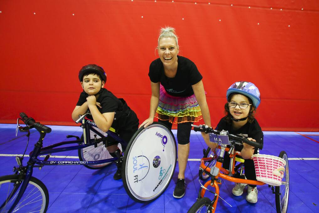 'MADE FOR IT': Nine-year-old Ashton Binskin, with tutu-clad exercise physiologist and coach Tracey Fredericks and five-year-old Mia Hill at the first session of Frame Running Wollongong. Picture: Anna Warr