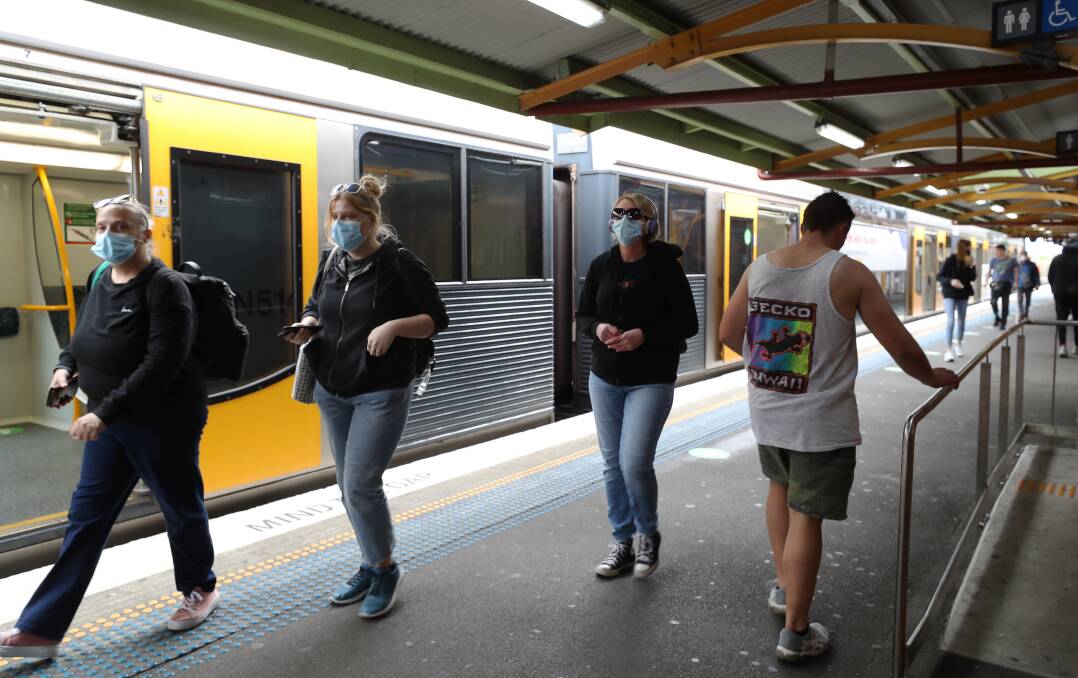 MASK UP: Commuters get off the trian in Wollongong on Thursday, wearing mandatory public transport face masks. Picture: Robert Peet.