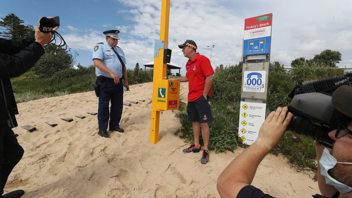 Chief Inspector Darren Brown and Surf Life Saving Illawarra duty officer Anthony Turner with the emergency phone at Puckey's. Picture: Robert Peet