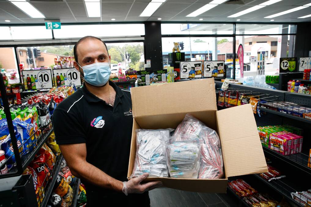 COMMUNITY: Metro Petroleum Wollongong employee Bashar Allshada with a freshly-opened box of Rapid Antigen Tests. Picture: Anna Warr.