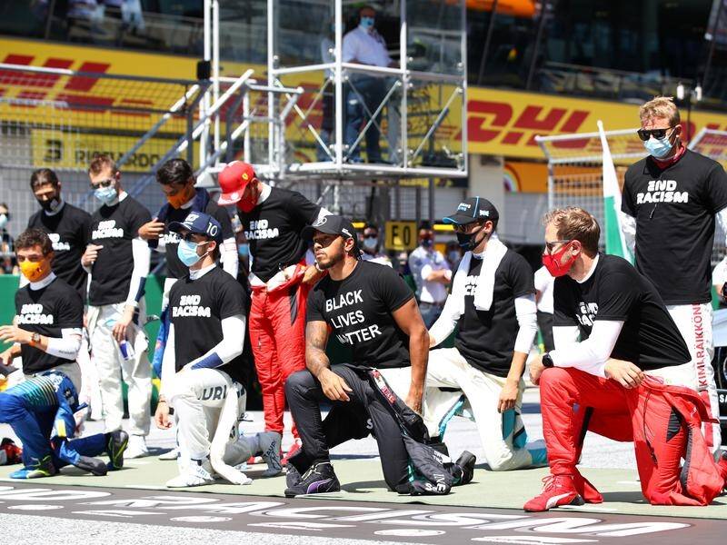 World Champion Lewis Hamilton kneels wearing an anti-racism T-shirt before the Austrian GP.