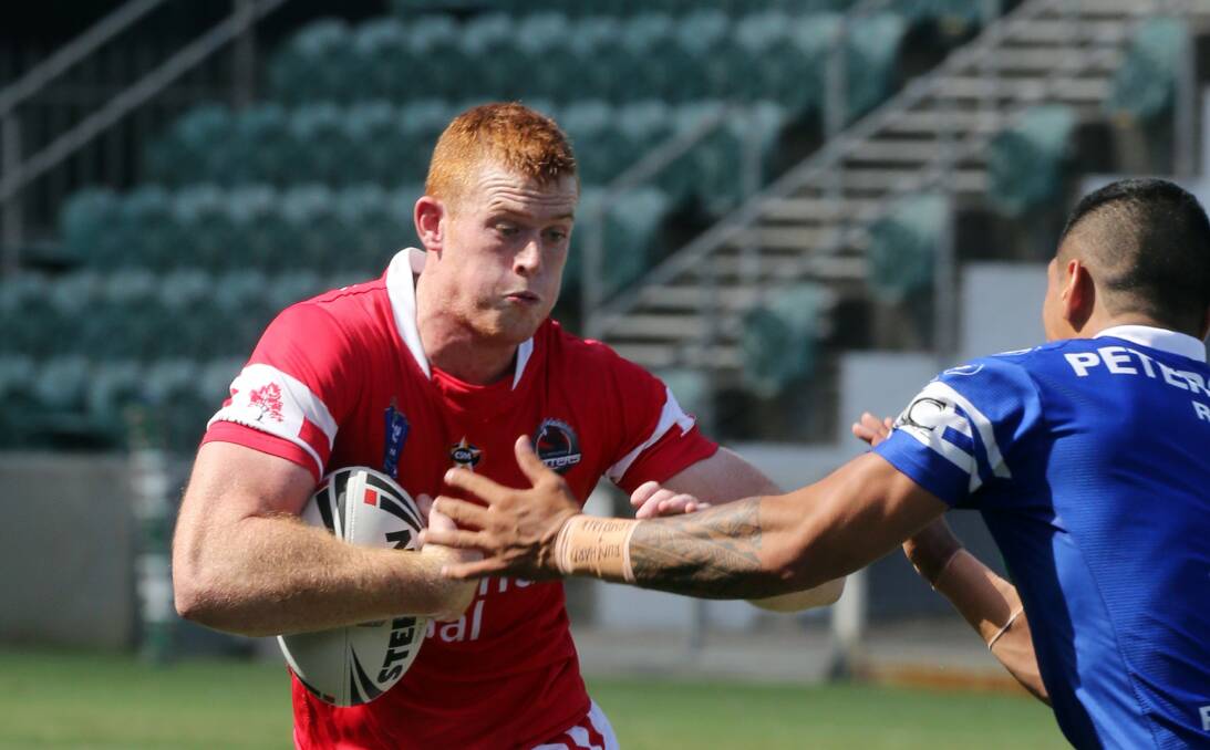 Cutters player Nathan Green attempts to beat a Newtown defender at WIN Stadium.