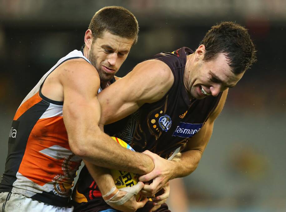 Hawk Jonathon Ceglar is tackled by the Giants' Callan Ward at the MCG on Sunday. Picture: GETTY IMAGES