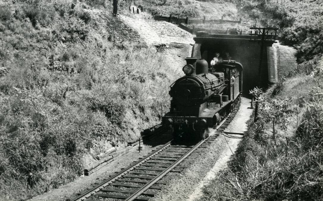 A train emerges from the Coal Cliff (Clifton) railway tunnel in the 1960s. The photo shows some remedial works to stop the embankment from slipping. Picture: From the collections of WOLLONGONG CITY LIBRARY and ILLAWARRA HISTORICAL SOCIETY