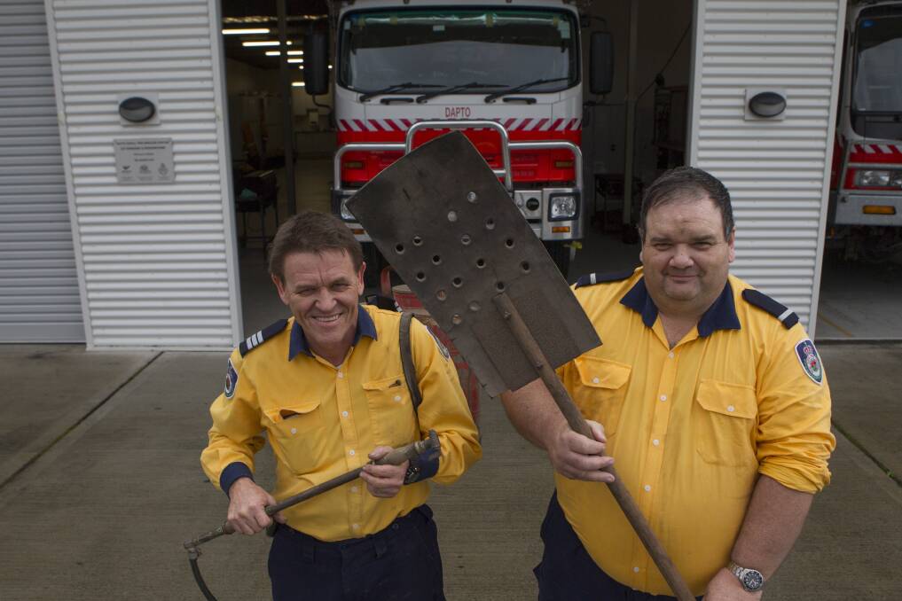 Dapto Rural Fire Brigade captain Harvey Bailey and deputy captain Mark Collins with firefighting gear from the 1940s. Picture: CHRISTOPHER CHAN