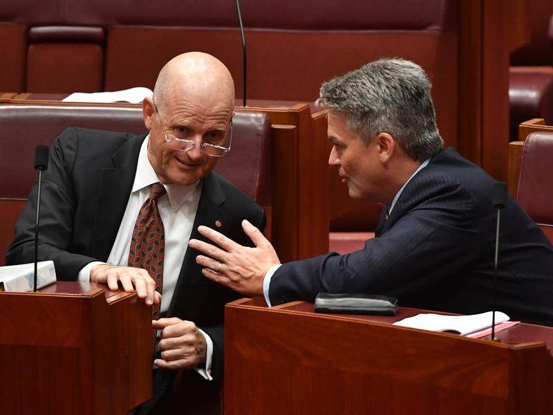 Finance Minister Mathias Cormann (r) is talking to the crossbench over company tax cuts.
