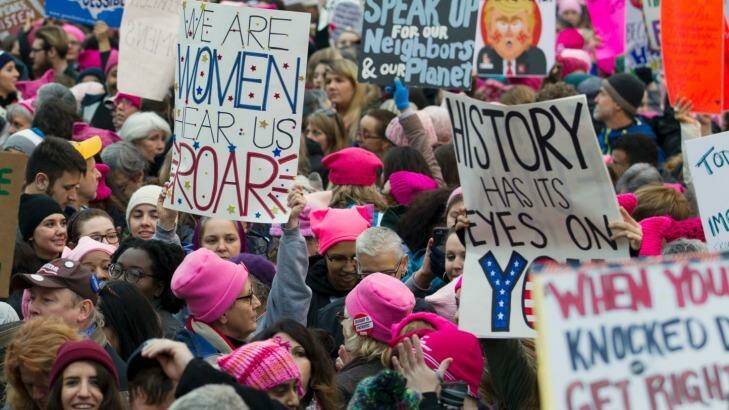 Women with bright pink hats and signs begin to gather early in Washington for the anti-Trump protest. Photo: JOSE LUIS MAGANA