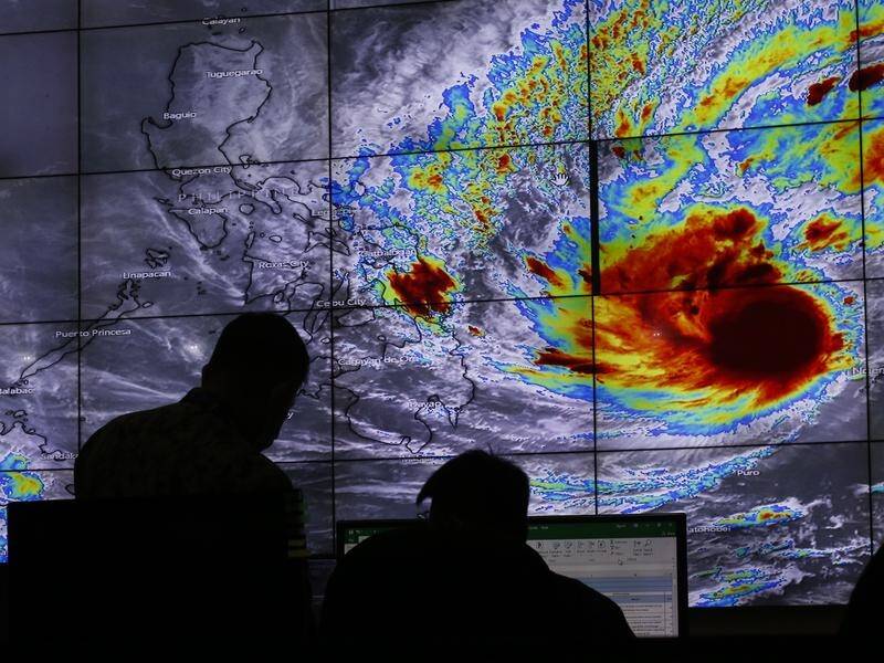 Staff at the Philippines' weather bureau track the progress of Typhoon Rai.