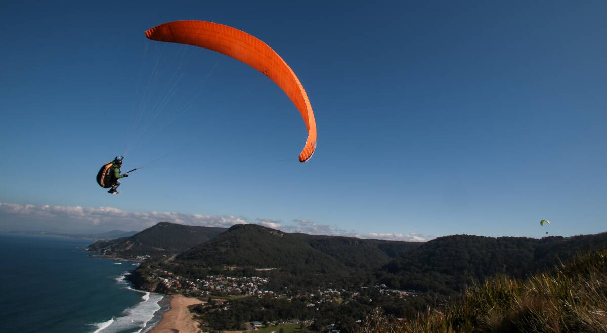 Up, up and away: Paragliders at Bald Hill in Stanwell Park make the most of the clear blue skies and windy conditions. Picture: ADAM McLEAN
