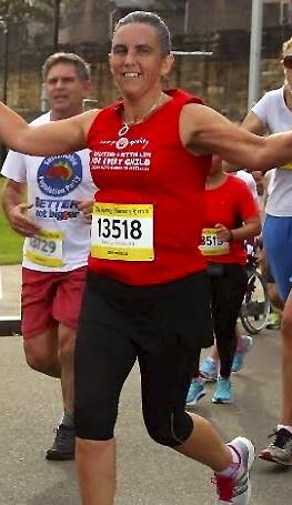 Jacqueline James, 41, crosses the finish line at the Gold Coast Airport Marathon on Sunday.