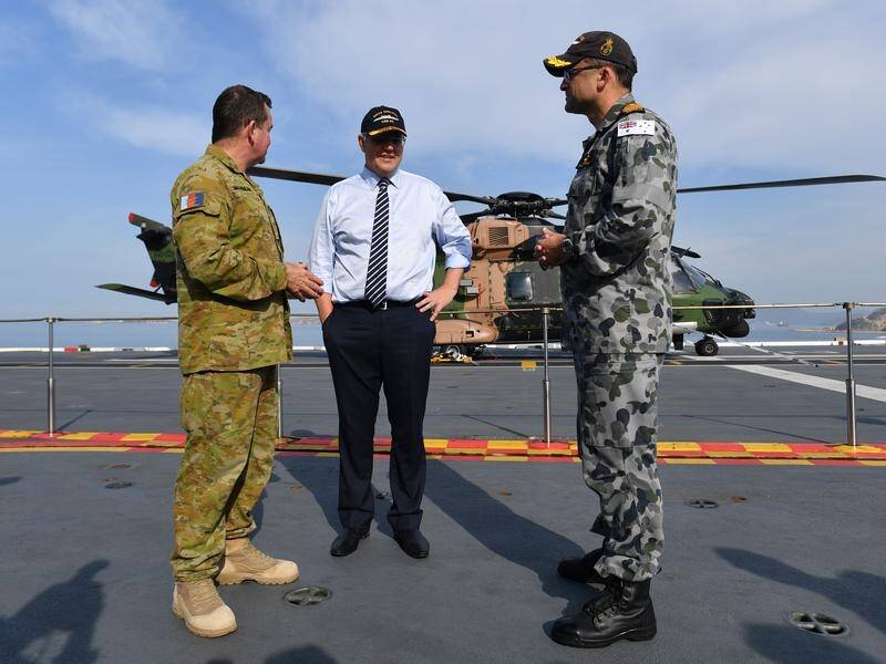 Scott Morrison (centre), seen on the HMAS Adelaide, says the new base is a PNG initiative.