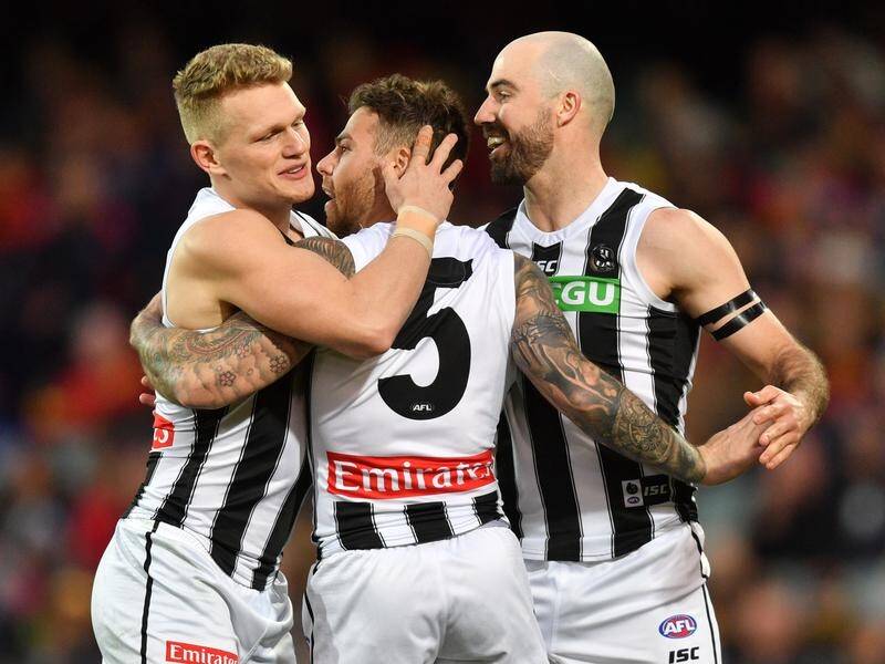 Jamie Elliott (C) kicked five goals as Collingwood hammered the Crows by 66 points at Adelaide Oval.