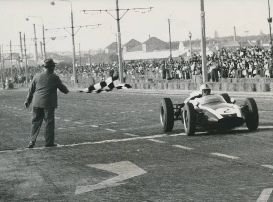 Jack Brabham takes the chequered flag in one of his many career wins.